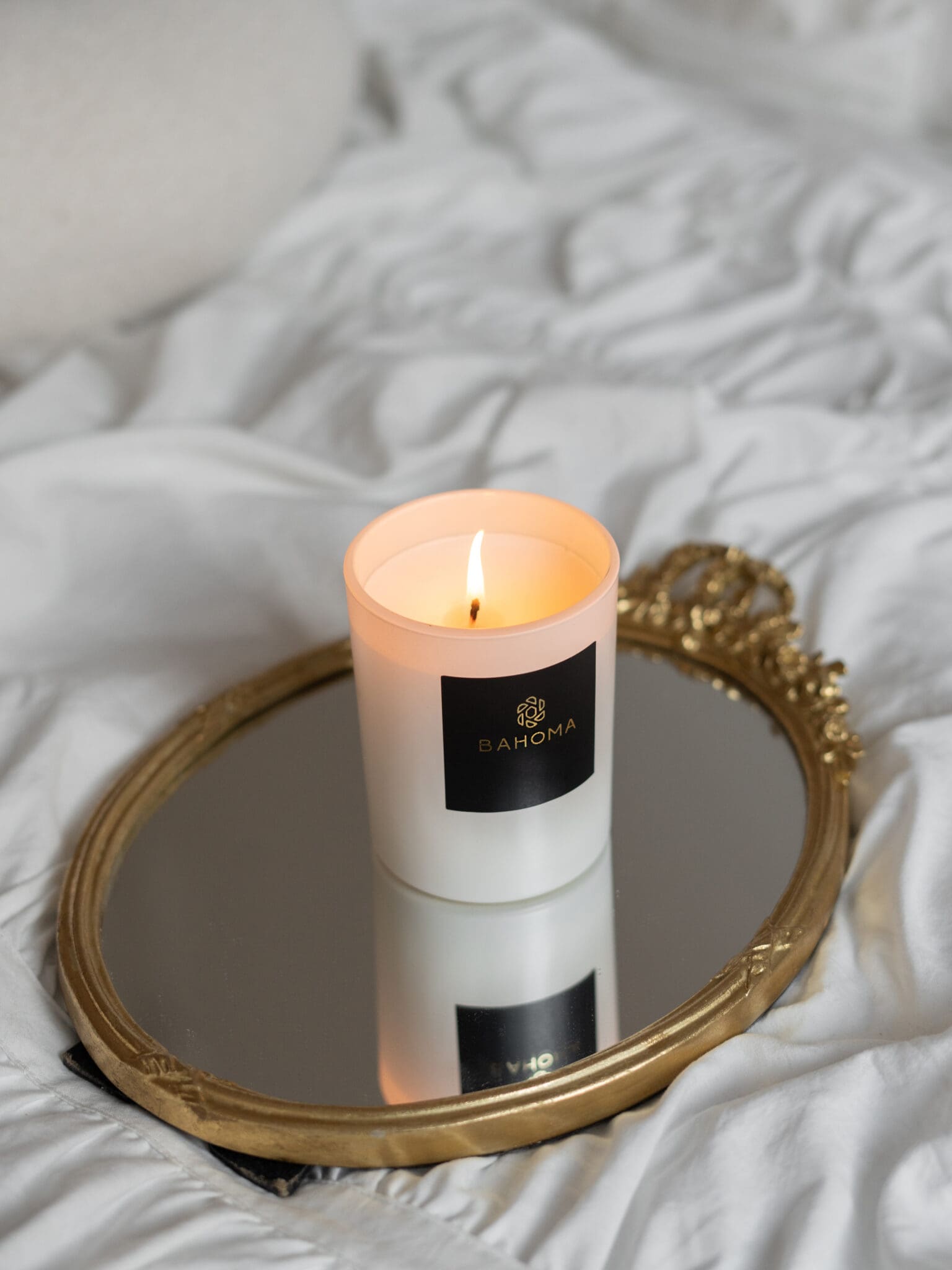 luxury-scented-candle-pearl-collection-lit-up-white-vessel-white-wax-on-a-mirror