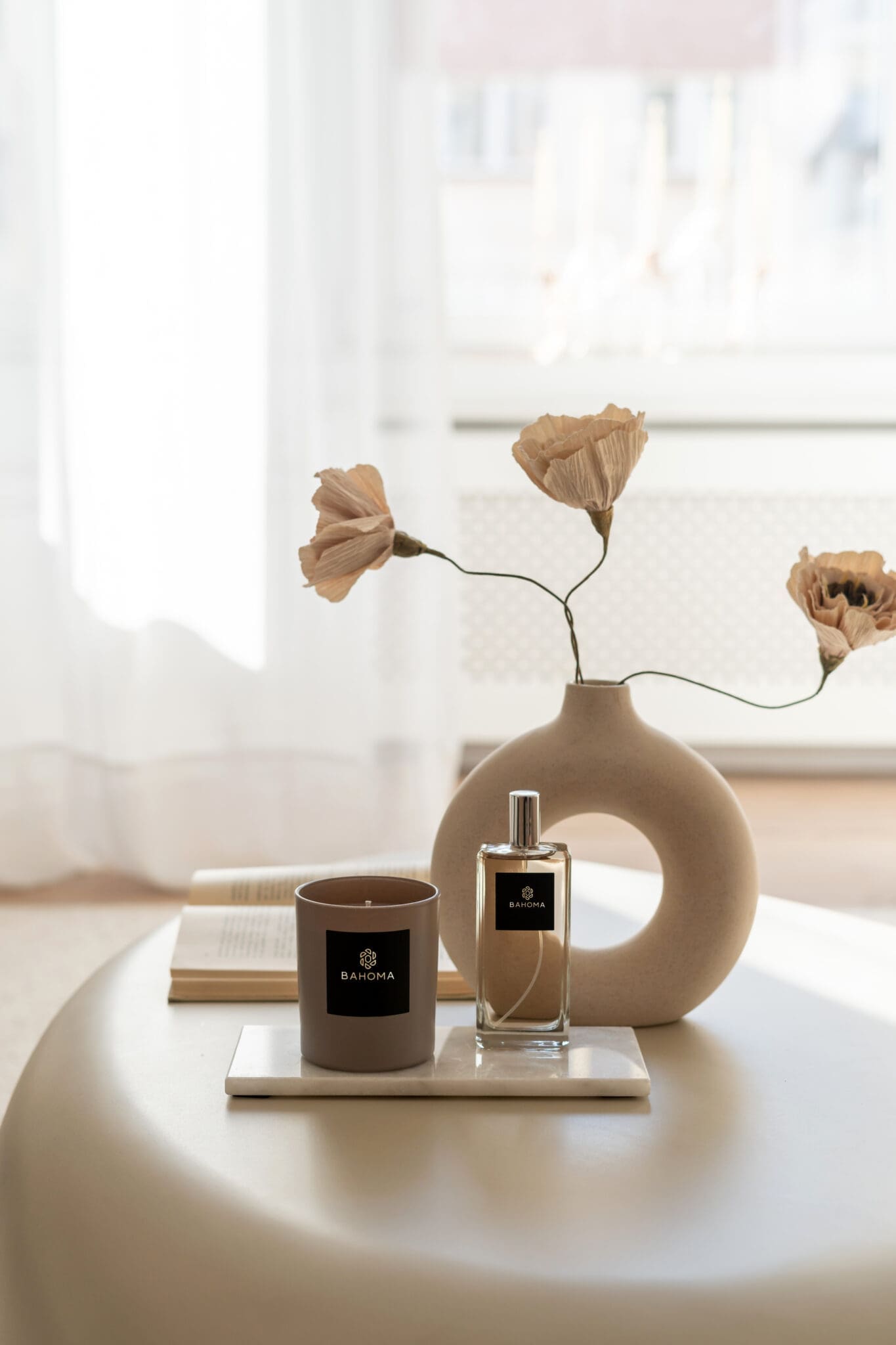 luxury-scented-candle-sand-collection-satin-taupe-mocca-glass-vessel-mocca-taupe-wax-on-a-coffee-table-luxury-steeing-with-vase