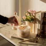 Cherry Blossom Scented Small Pillar Candle styled on a marble surface being lit.