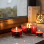 Bahoma red 3-wick Christmas candle on windowsill – warm festive ambience