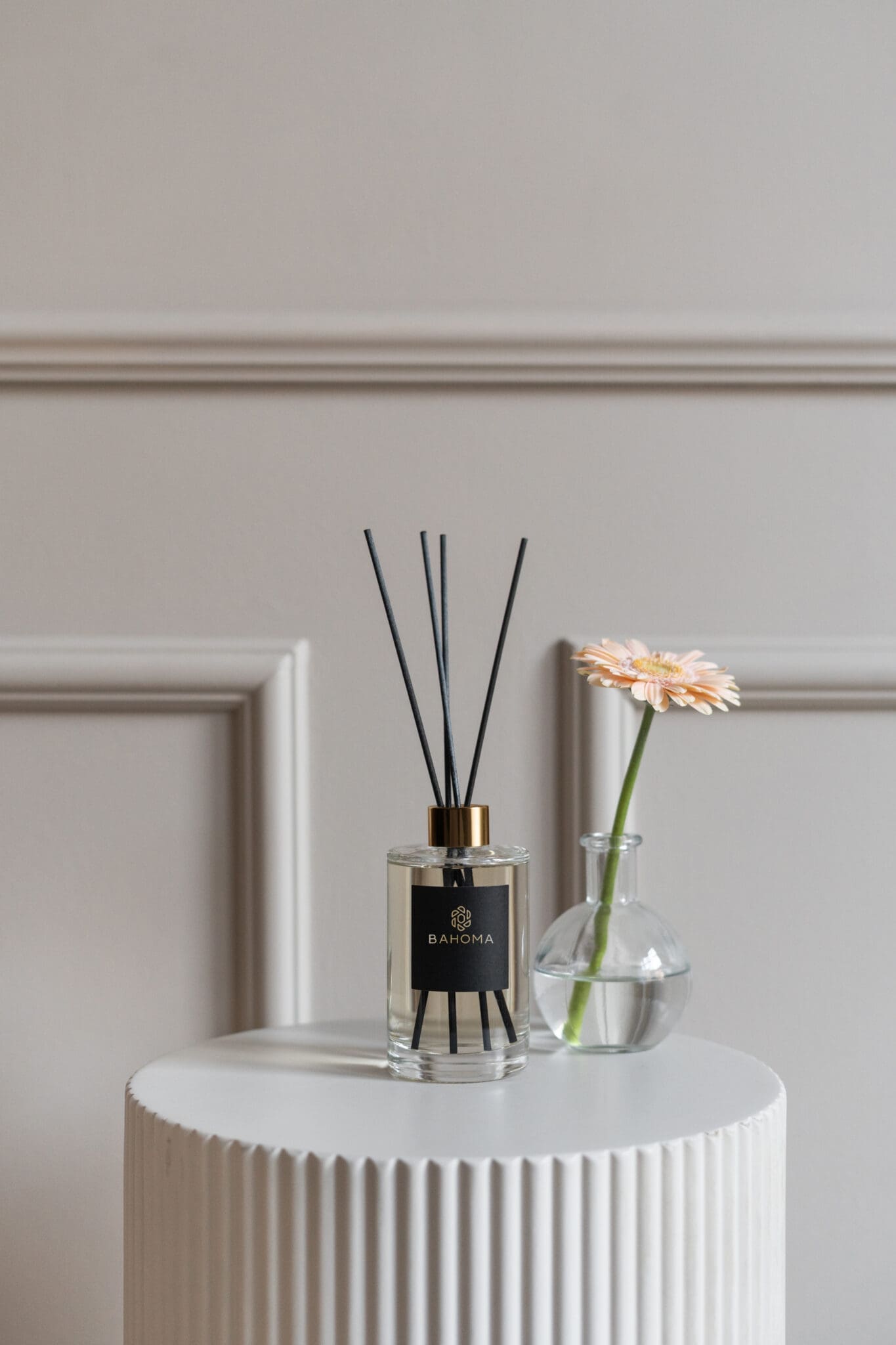 wild-heather-and-oakwood-200ml-diffuser-alchemy-collection-with-black-reeds-on-a-table-with-a-small-vase-with-gerbera-flower