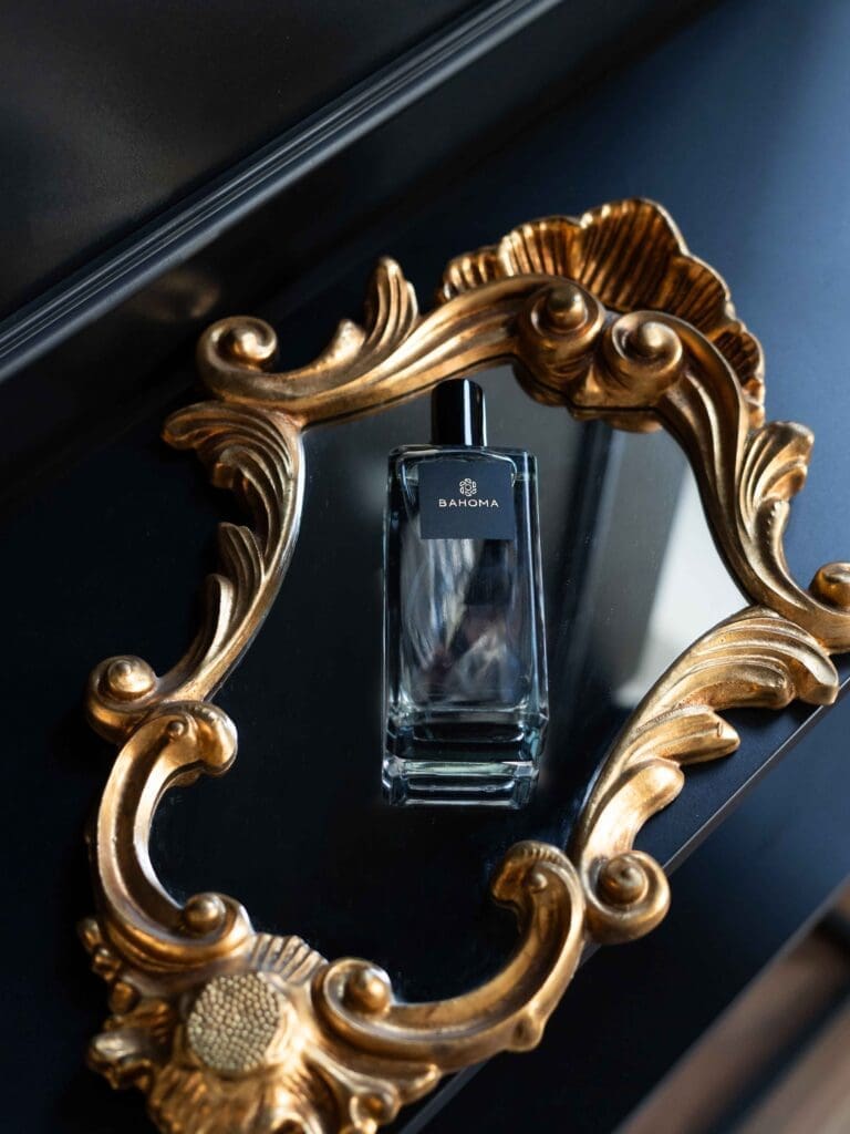 Black Home Fragrance - Bahoma London Obsidian collection black room spray bottle reflected on a vintage gold ornate mirror